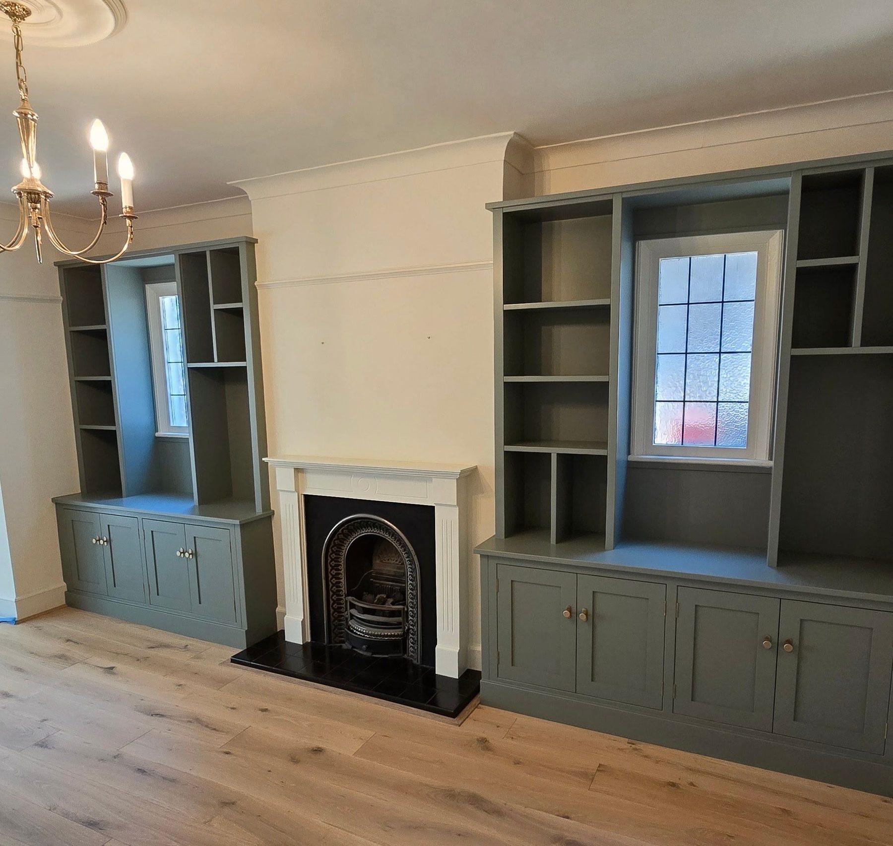 Alcove cabinetry and shelving either side of a fireplace